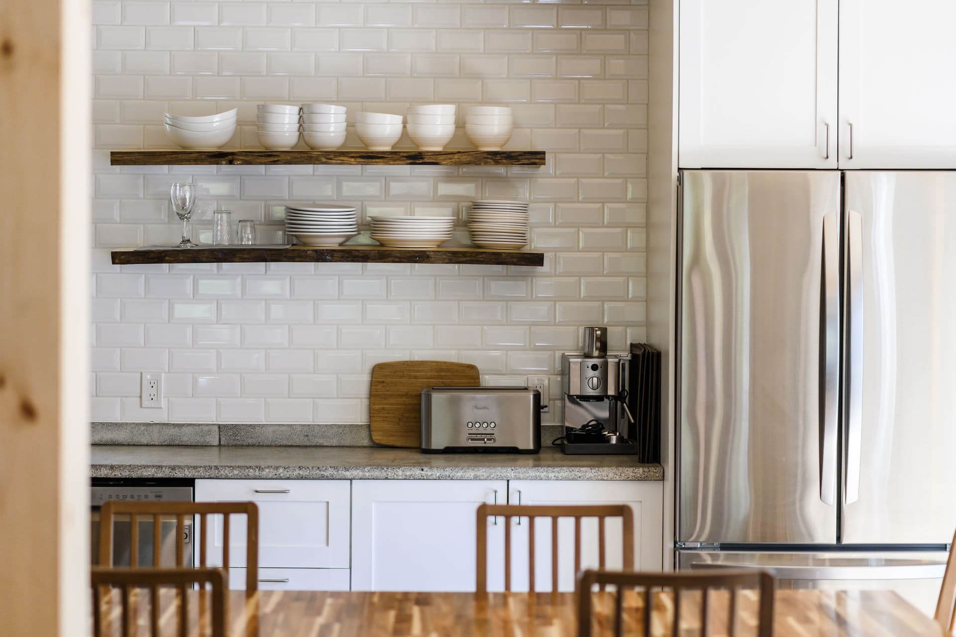 Kitchen open shelving with dishes and refrigerator