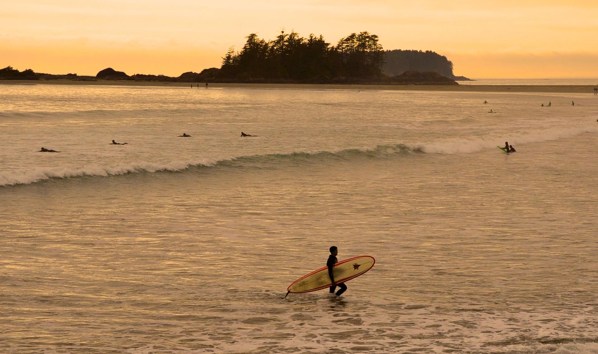 Surfer riding waves at Chesterman Beach, Tofino BC