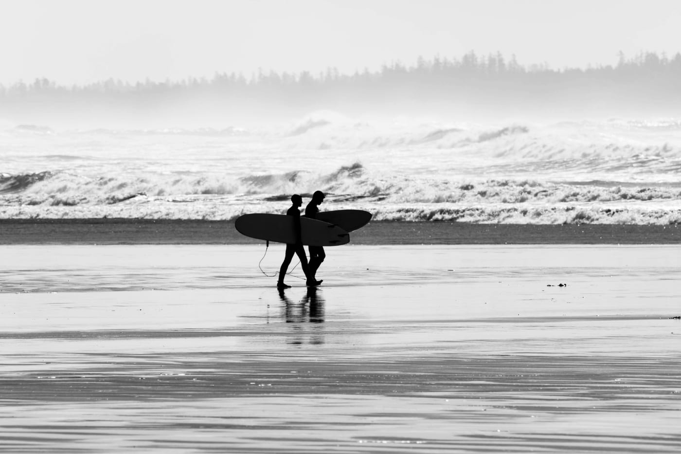 Surfboards lined up on Long Beach Tofino with Pacific waves in background
